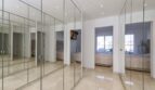 Ankleidebereich mit raumhohen Spiegelschränken im Luxus-Penthouse Palma, helle Bodenfliesen, Blick ins Schlafzimmer
