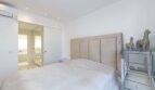Helles Schlafzimmer mit gepolstertem Kopfteil, Spiegelkommode und en-suite Bad im Luxus-Penthouse Palma