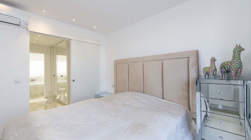 Helles Schlafzimmer mit gepolstertem Kopfteil, Spiegelkommode und en-suite Bad im Luxus-Penthouse Palma