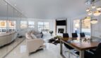 Helles Wohnzimmer mit Spiegelwand, Designermöbeln, Kamin und Panoramafenstern im Luxus-Penthouse Palma