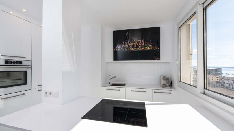 Moderne weiße Küche mit Kochinsel, Bosch-Einbaugeräten und Meerblick im Luxus-Penthouse Palma de Mallorca