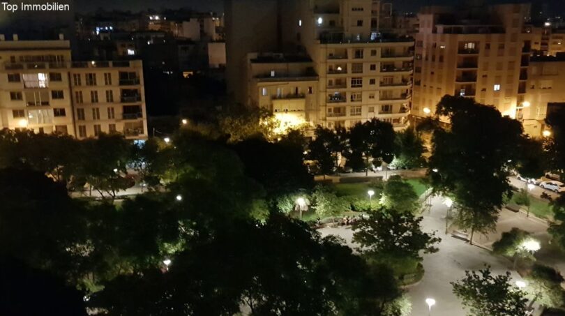 Nächtlicher Blick vom Penthouse auf beleuchteten Park in Palma de Mallorca mit umliegenden Stadtgebäuden