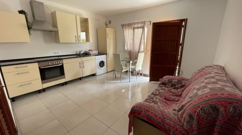 Helles Wohn-Kochzimmer mit Einbauküche, Waschmaschine, Esstisch und Sofa im Zweifamilienhaus Portocolom