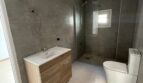 Modernes Badezimmer mit walk-in Dusche, Holzunterschrank und WC im Zweifamilienhaus Portocolom