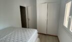Schlafzimmer mit Doppelbett, weißem Einbauschrank und Holzboden im Zweifamilienhaus Portocolom