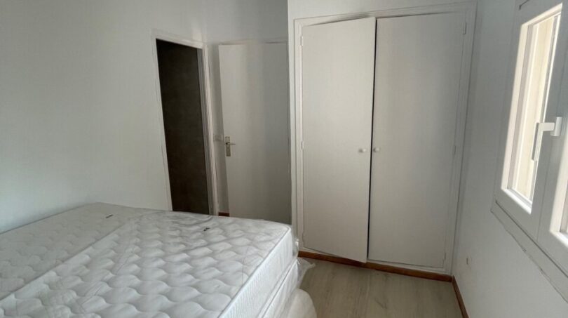 Schlafzimmer mit Doppelbett, weißem Einbauschrank und Holzboden im Zweifamilienhaus Portocolom