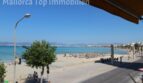 Strandpromenade El Arenal mit türkisblauem Meer, Sonnenschirmen und Bergpanorama – direkte Meereslage der Wohnung