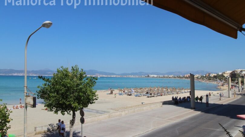 Strandpromenade El Arenal mit türkisblauem Meer, Sonnenschirmen und Bergpanorama – direkte Meereslage der Wohnung