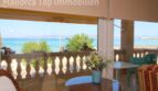 Verglaste Terrasse einer Strandwohnung in El Arenal mit Meerblick, Sitzecke und türkisblauem Mittelmeer.
