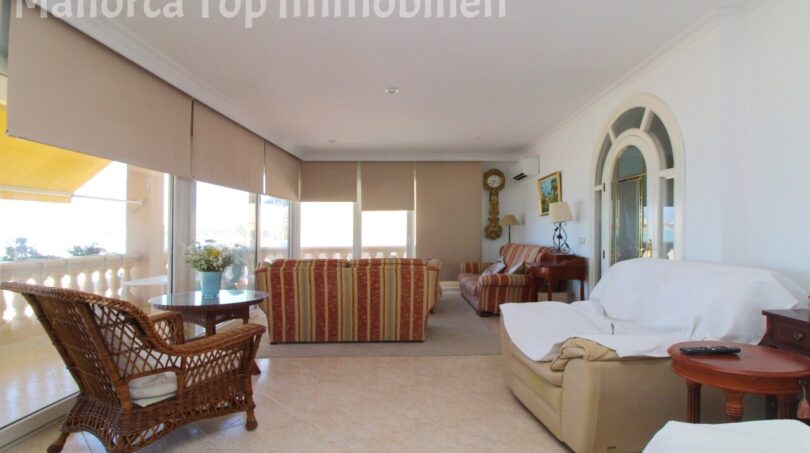 Helles Wohnzimmer mit Rattanstuhl, gestreiften Sofas, Panoramafenster und Meerblick-Terrasse in Meereslinie-Wohnung El Arenal