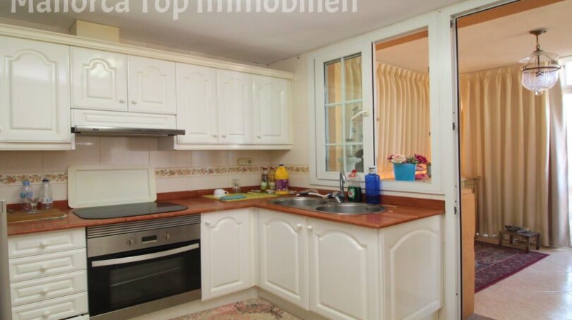 Helle Einbauküche mit weißen Fronten, Cerankochfeld, Einbauofen und Doppelspüle in Mallorca-Wohnung El Arenal