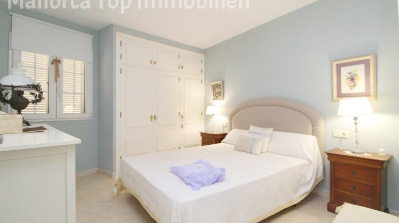 Helles Schlafzimmer mit Doppelbett, weißem Einbauschrank und hellblauen Wänden in Meereslinie-Wohnung El Arenal