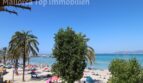 Strandblick aus Wohnung in El Arenal: Türkises Meer, Sandstrand, Palmenbäume, Boote und Badegäste in Palma de Mallorca.