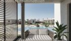 Sonniger Balkon mit Loungesofa und Blick auf den Gemeinschaftspool der Neubauwohnungen bei Es Trenc, Sa Ràpita.