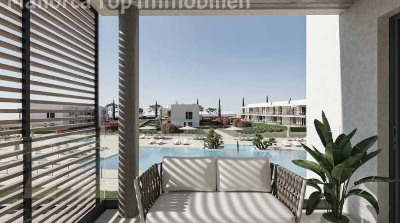 Sonniger Balkon mit Loungesofa und Blick auf den Gemeinschaftspool der Neubauwohnungen bei Es Trenc, Sa Ràpita.