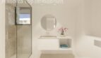Modernes Badezimmer einer Neubauwohnung bei Es Trenc mit Glasdusche, Waschtisch und Badewanne.