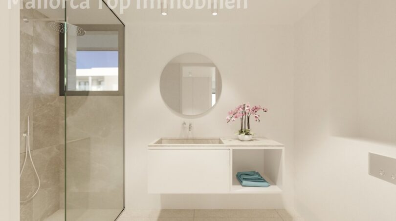 Modernes Badezimmer einer Neubauwohnung bei Es Trenc mit Glasdusche, Waschtisch und Badewanne.