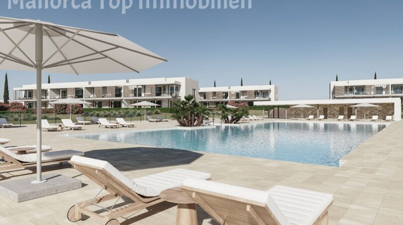 Poolanlage mit Liegestühlen und Sonnenschirmen, moderne Neubauwohnungen in Sa Ràpita im Hintergrund.