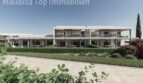 Außenansicht moderner Neubau-Wohnanlage bei Es Trenc mit gepflegtem Garten, Terrassen und mediterraner Bepflanzung.