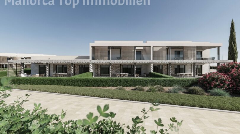 Außenansicht moderner Neubau-Wohnanlage bei Es Trenc mit gepflegtem Garten, Terrassen und mediterraner Bepflanzung.