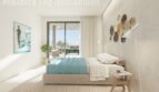 Helles Schlafzimmer einer Neubauwohnung bei Es Trenc mit Doppelbett, Terrassenzugang und mediterranem Dekor.