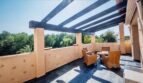 Terraza azotea soleada con pérgola, muebles de ratán y vistas a las palmeras en Calvia