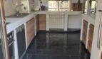 Espaciosa cocina de la villa en Calvia con suelo de pizarra negra, azulejos blancos e isla de cocina