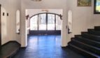 Elegante zona de entrada de la villa con suelo de pizarra negra, puerta de arco redondo y escalera en Calvia.