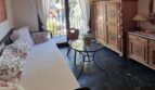 Dormitorio rústico de la villa en Calvia con armario pintado, balcón, techo de vigas de madera y suelo de piedra natural.
