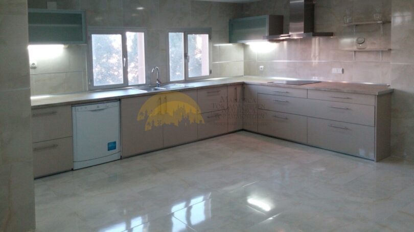 Moderne Einbauküche mit Marmorboden, L-Form-Küchenzeile und Edelstahl-Dunstabzug in Palma-Hafenwohnung