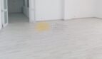 Heller, leerer Wohnraum mit hellgrauem Laminatboden und weißen Wänden in Hafenwohnung Palma de Mallorca
