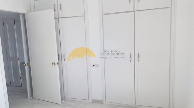Helles Schlafzimmer mit großen Einbauschränken und hellem Laminatboden in Hafenwohnung Palma de Mallorca