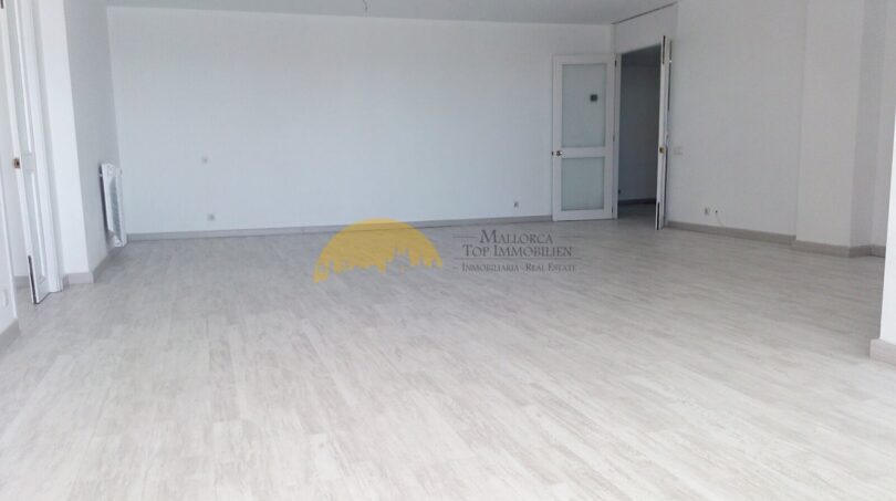 Heller, leerer Wohnraum mit weißem Laminatboden und modernen Glastüren in Hafenwohnung Palma de Mallorca