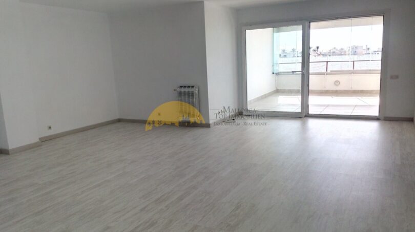 Heller, leerer Wohnraum mit Laminatboden und großer Glasfront zur Terrasse in Hafenwohnung Palma de Mallorca
