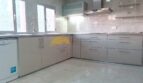 Moderne weiße Einbauküche mit Marmorboden, Dunstabzug und Spülmaschine in Hafenwohnung Palma de Mallorca