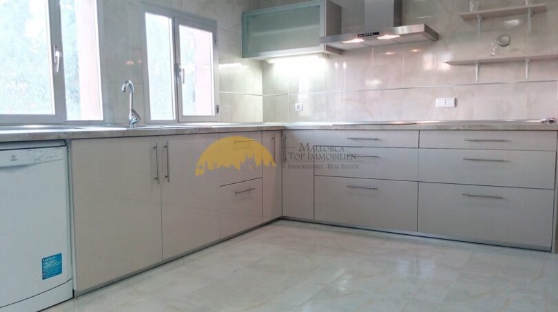 Moderne weiße Einbauküche mit Marmorboden, Dunstabzug und Spülmaschine in Hafenwohnung Palma de Mallorca