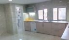 Moderne Küche mit Granitboden, hellen Schränken, Geschirrspüler und Fenster zur Gartenansicht in Palma