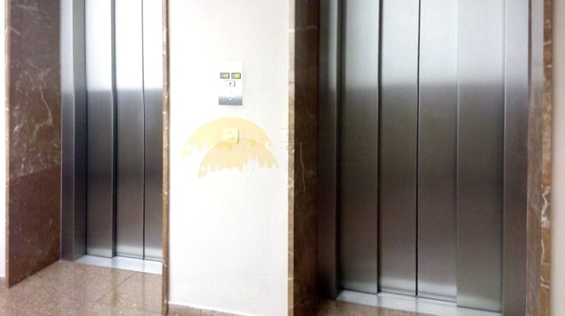 Zwei Aufzüge mit Edelstahltüren und Marmorverkleidung im eleganten Eingangsbereich der Hafenwohnung in Palma.