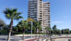 Hochhaus-Apartmentgebäude in Palma de Mallorca mit Palmen und Radweg in Hafennähe.