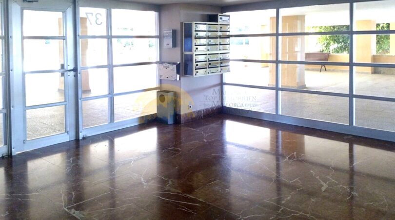 Helles Eingangsfoyer mit Marmorböden, Briefkastenanlage und großen Glasfronten in Wohnanlage Palma de Mallorca