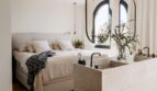Offenes Schlafzimmer mit Doppelwaschbecken, Hängespiegel und Bogenfenstern in Palma