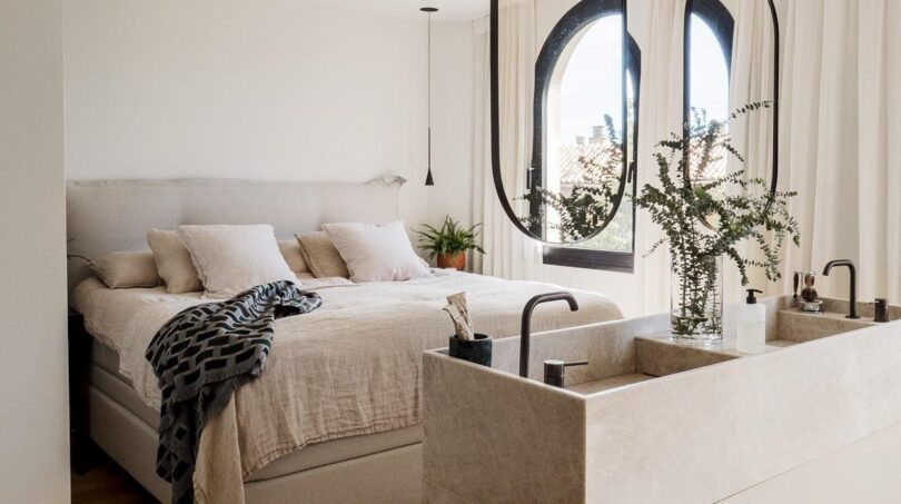 Offenes Schlafzimmer mit Doppelwaschbecken, Hängespiegel und Bogenfenstern in Palma