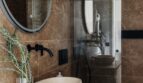 Luxuriöses Badezimmer mit Marmorwänden, Naturstein-Waschbecken, Holzwaschtisch und Glasdusche