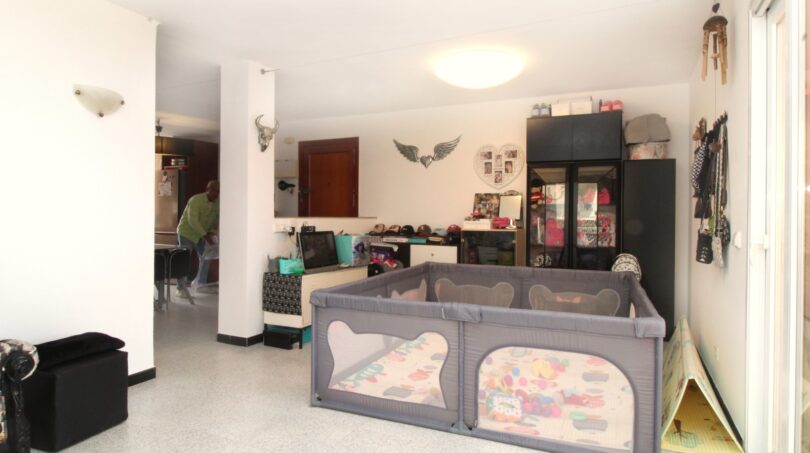 Helles Wohnzimmer mit Laufstall, Spielecke und Stauraumschrank in 3-Zimmer-Wohnung in Palma