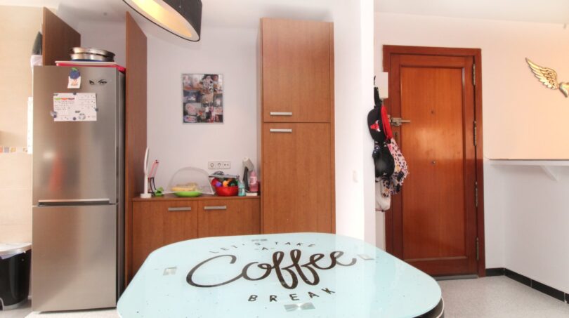 Küche mit Kühlschrank, Holzschränken und einem Tisch mit Coffee-Break-Aufdruck in Palma de Mallorca