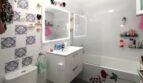 Modernes Badezimmer mit beleuchtetem Spiegel, Badewanne, Waschtisch und dekorativen Damast-Fliesen in Palma de Mallorca