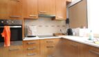 Moderne Küche mit Holzfronten, Einbauofen, Glaskeramikkochfeld und Edelstahlgriffen in Palma de Mallorca