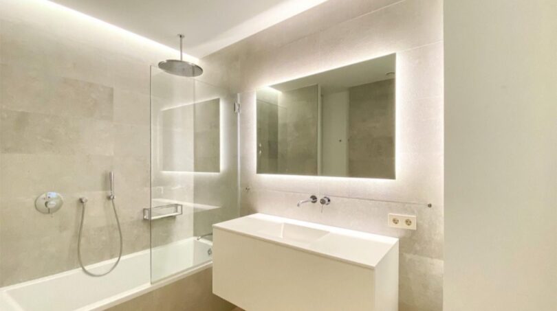 Modernes Badezimmer der Maisonette in Palma mit Badewanne, Regendusche, beleuchtetem Spiegel und schwebenden Waschtisch.