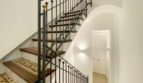 Elegantes Treppenhaus der Maisonette in Palma mit schmiedeeisernem Geländer und historischen Mosaikfliesen.