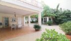 Überdachte Terrasse der Villa in Alcúdia mit Essbereich, Innenhof und üppigem Grün